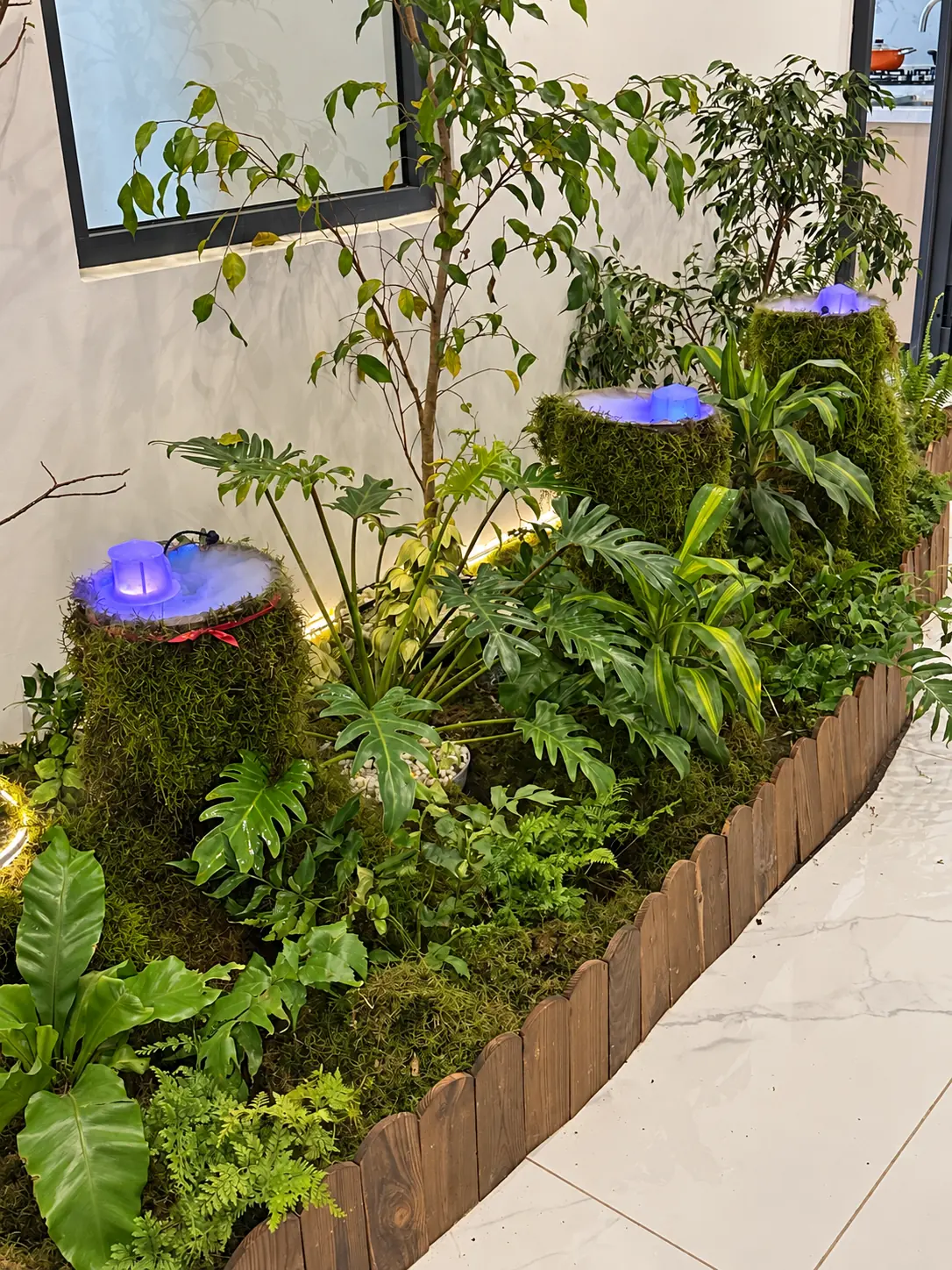 Planting detail with the illuminated water features, natural stone and layered foliage.